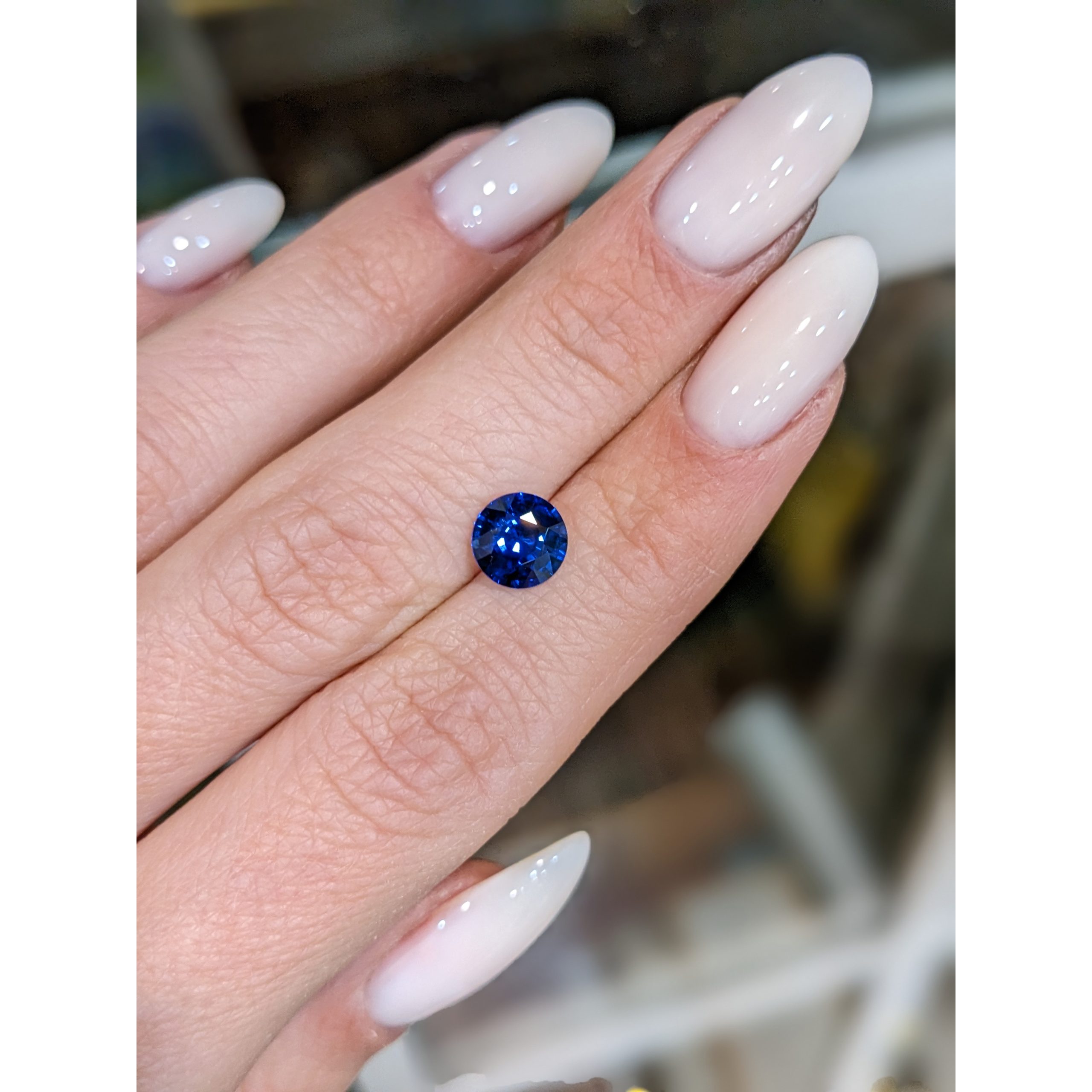 Natural 1.56 carat Ceylon blue round sapphire resting on a hand