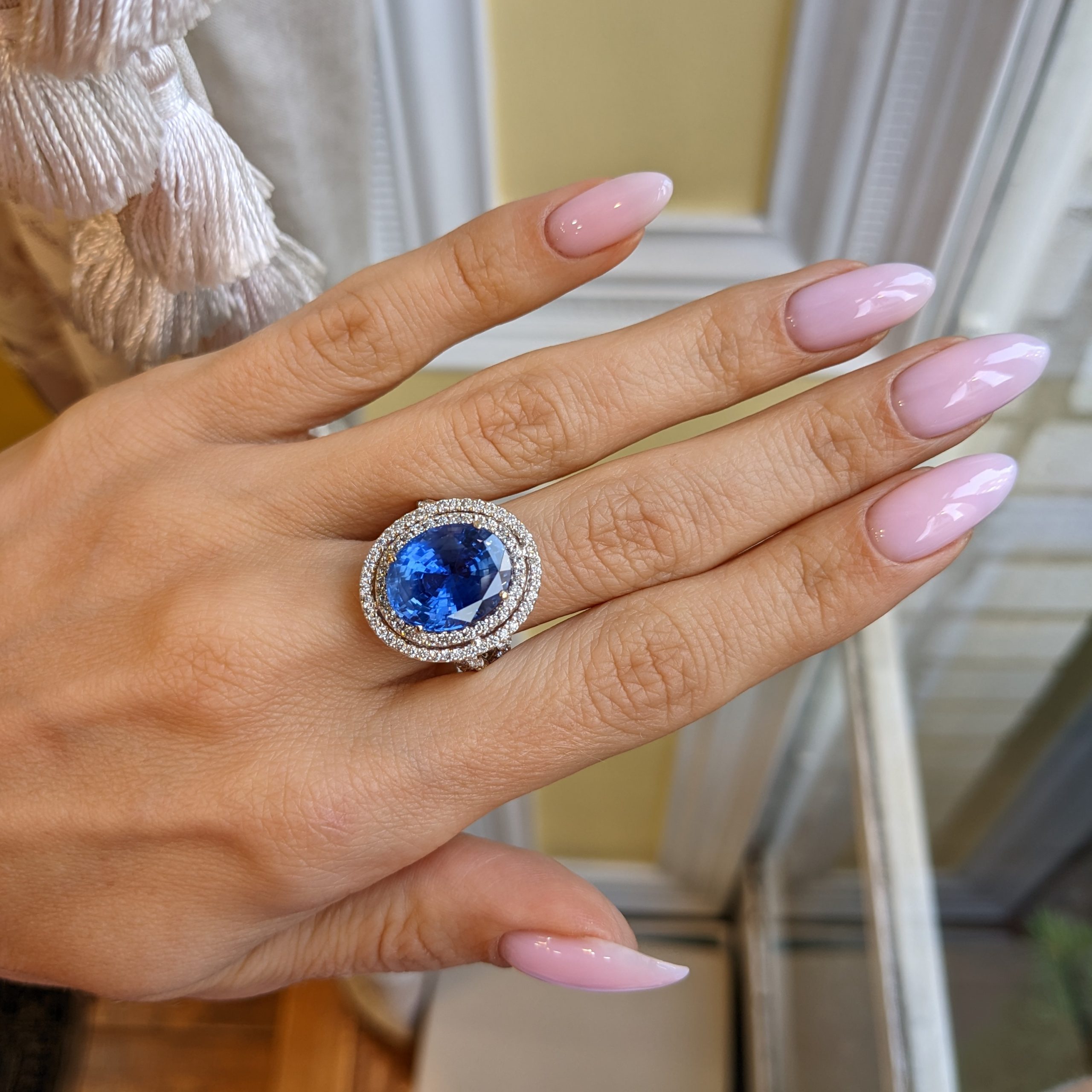 Oval blue sapphire halo ring J9755 worn on the hand